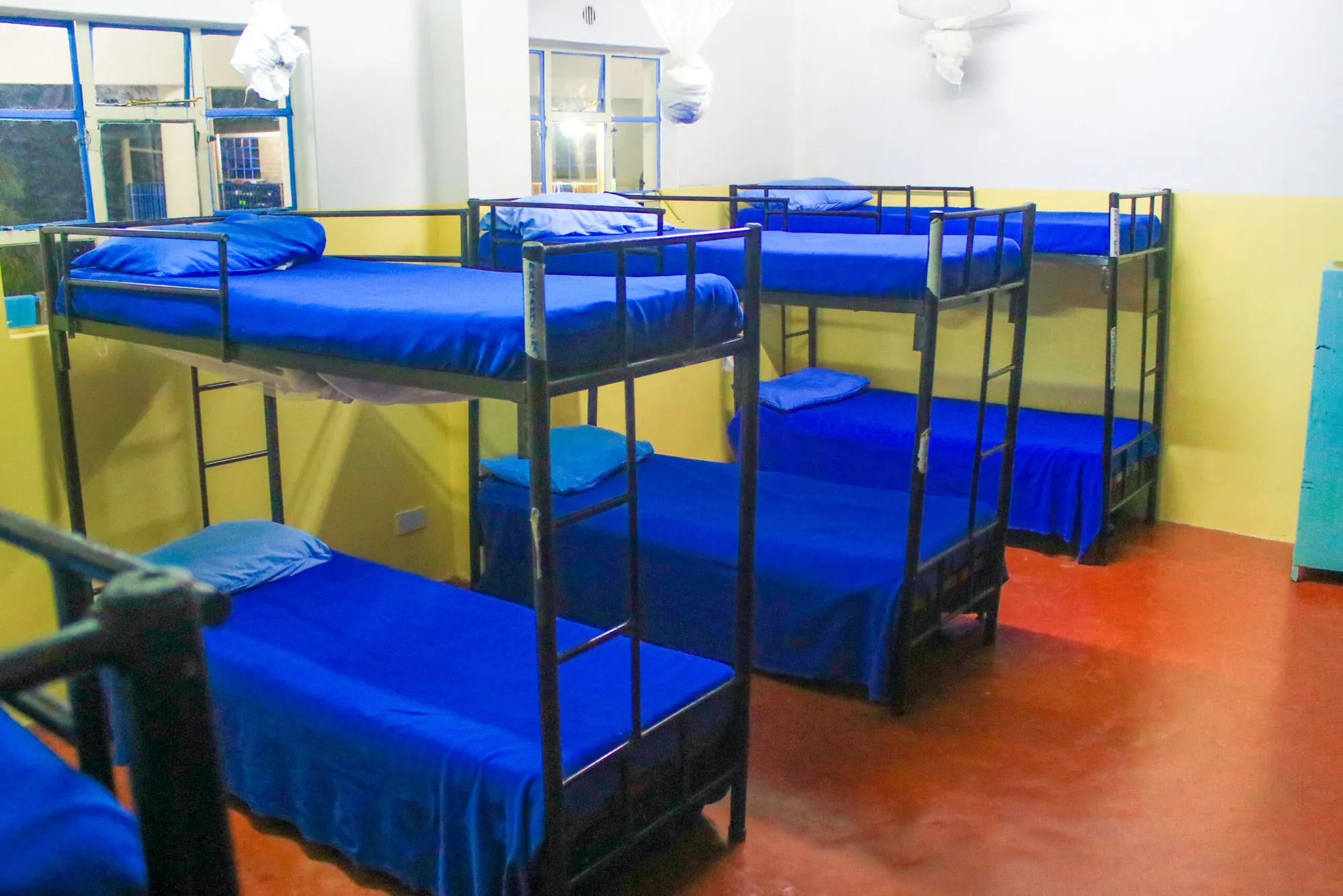 Boarding dormitory with blue-blanketed bunk beds