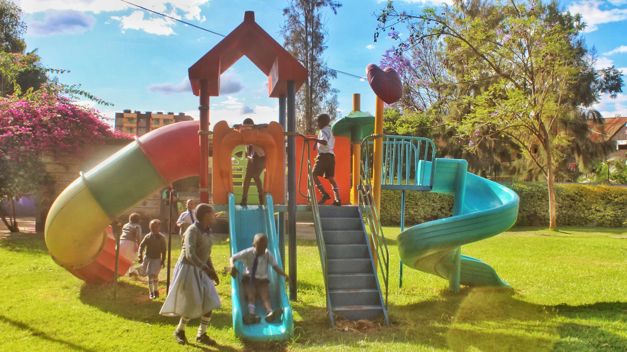 Children playing on a colourful playground with towers and slides