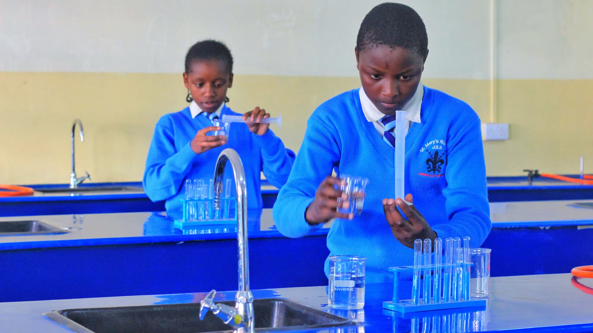 Two girls carrying out a science experiment at a laboratory sink