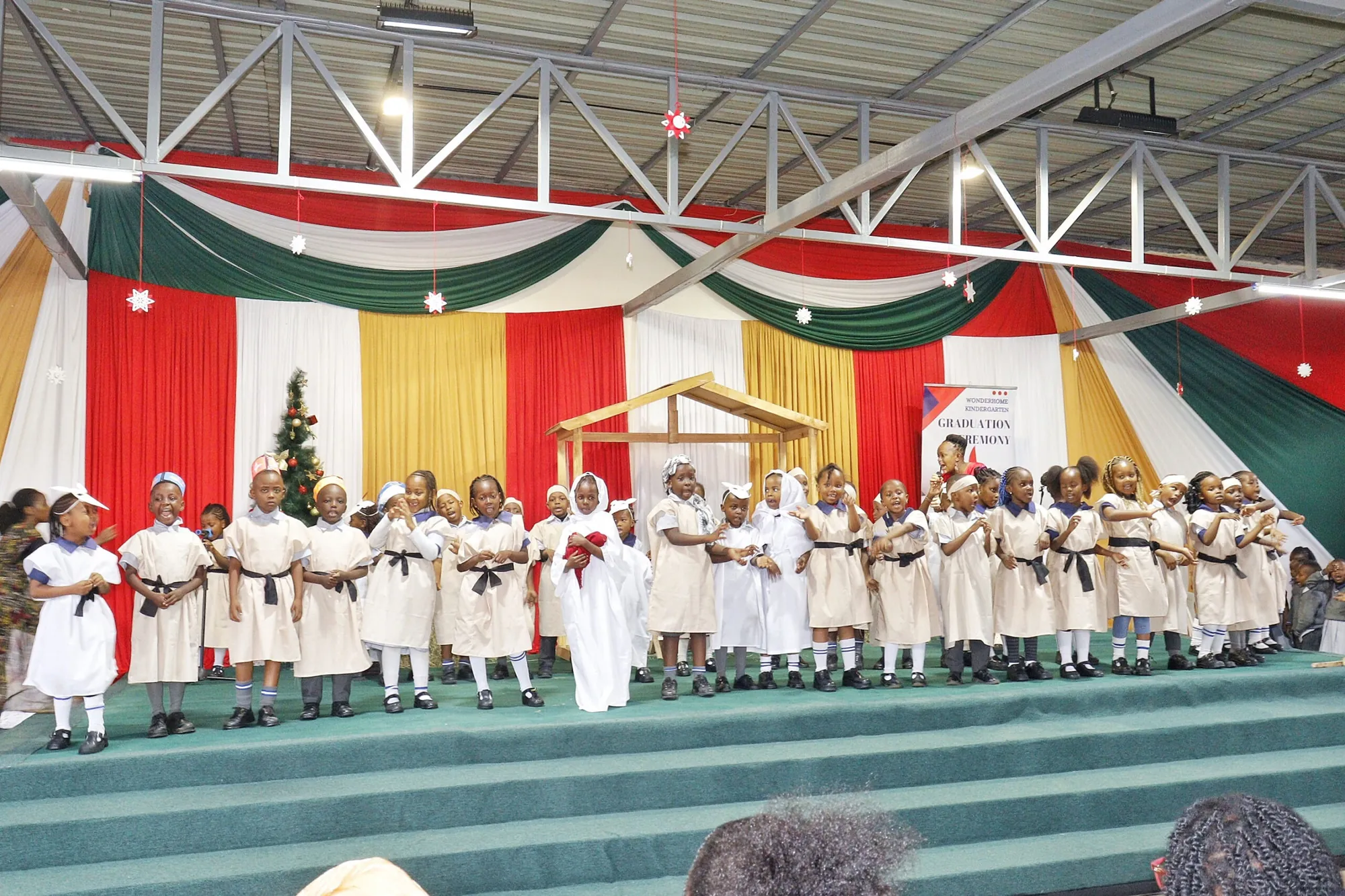 Nursery pupils singing together on a decorated stage