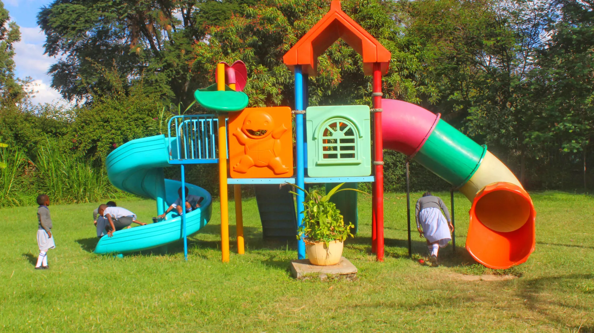 Colourful children's playground with slides on a green lawn