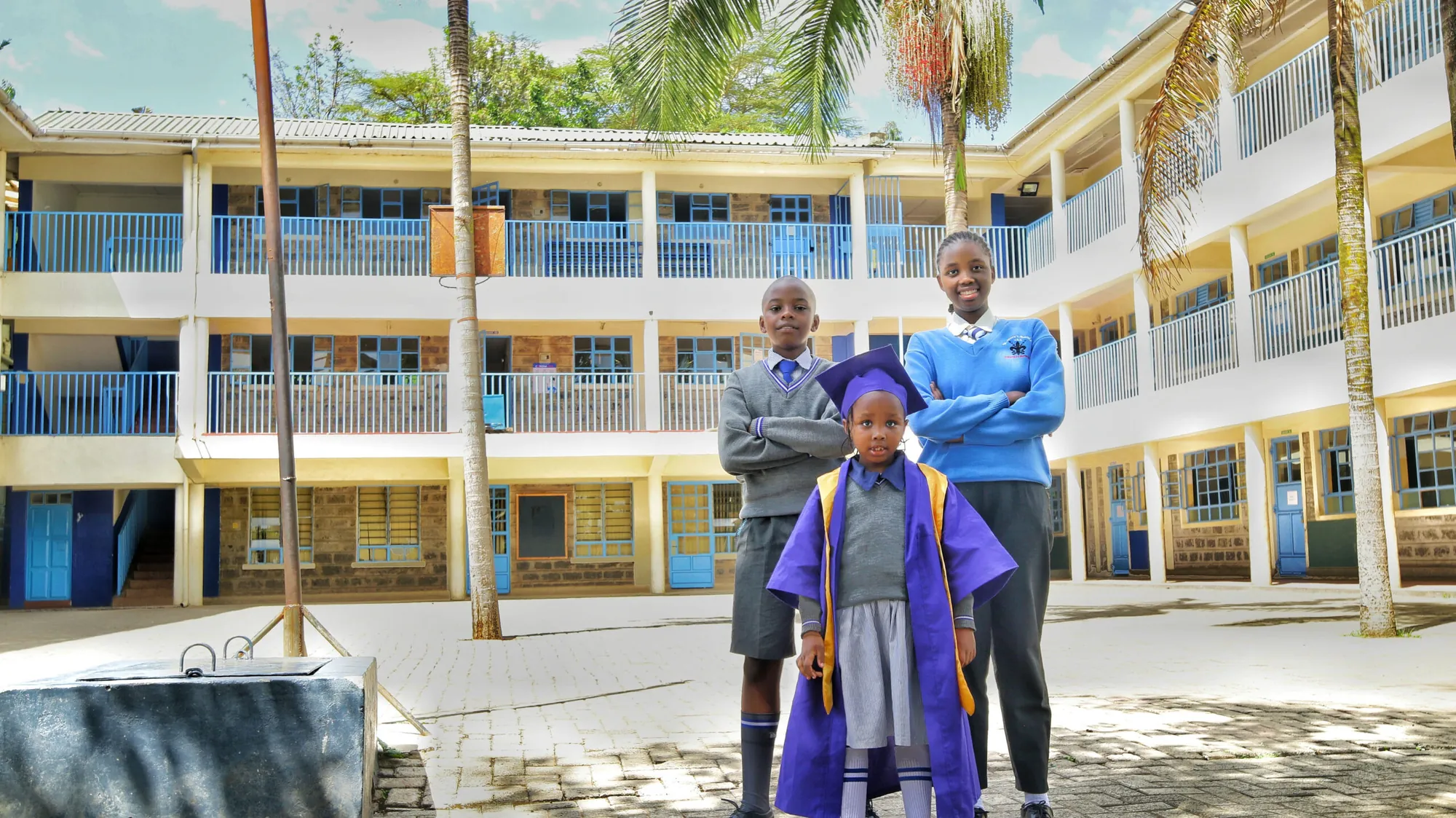 Pupils standing in front of the school building in the sunshine